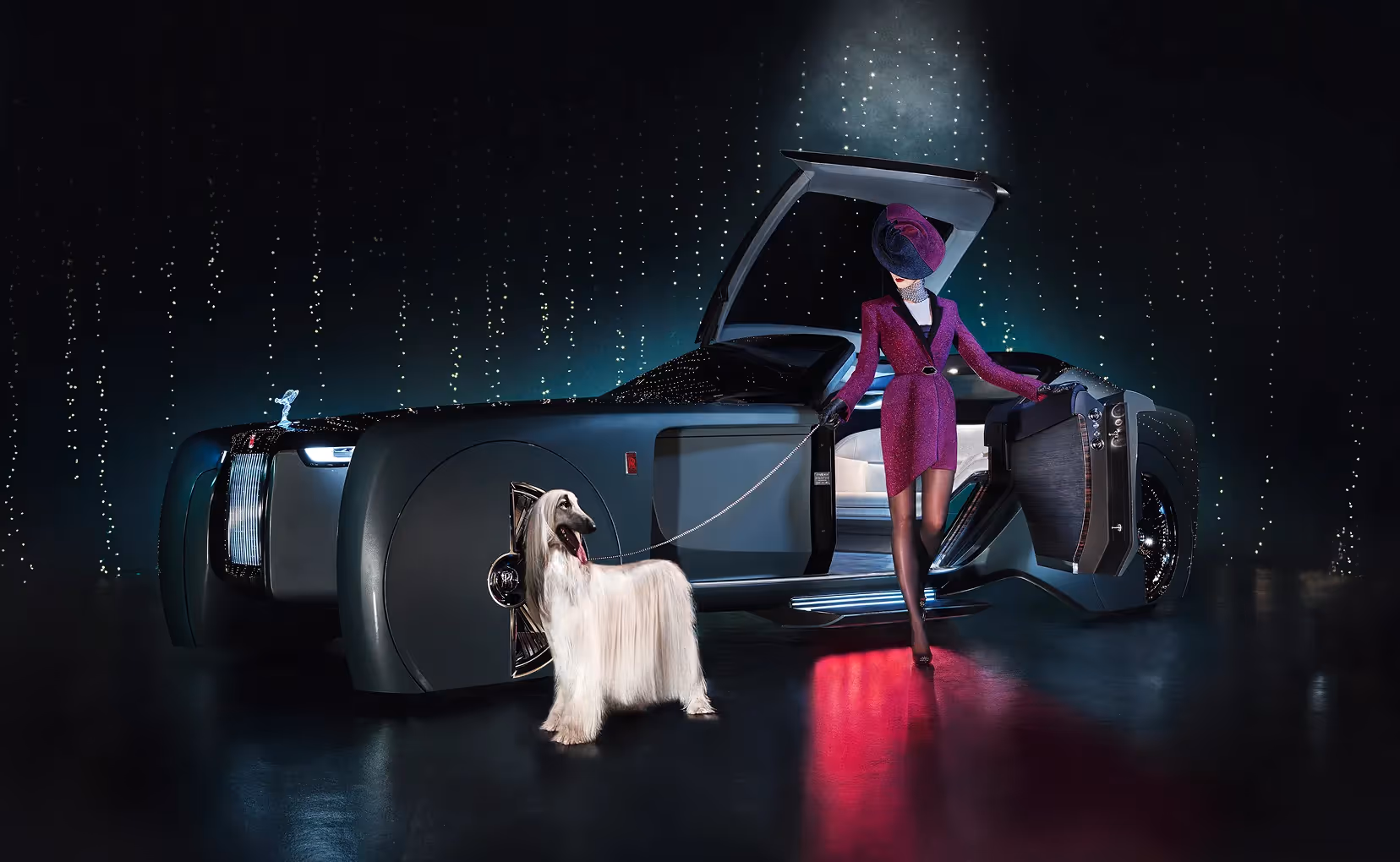 Frau in auffälligem Outfit steht neben geöffnetem Rolls-Royce Fahrzeug mit einem Hund