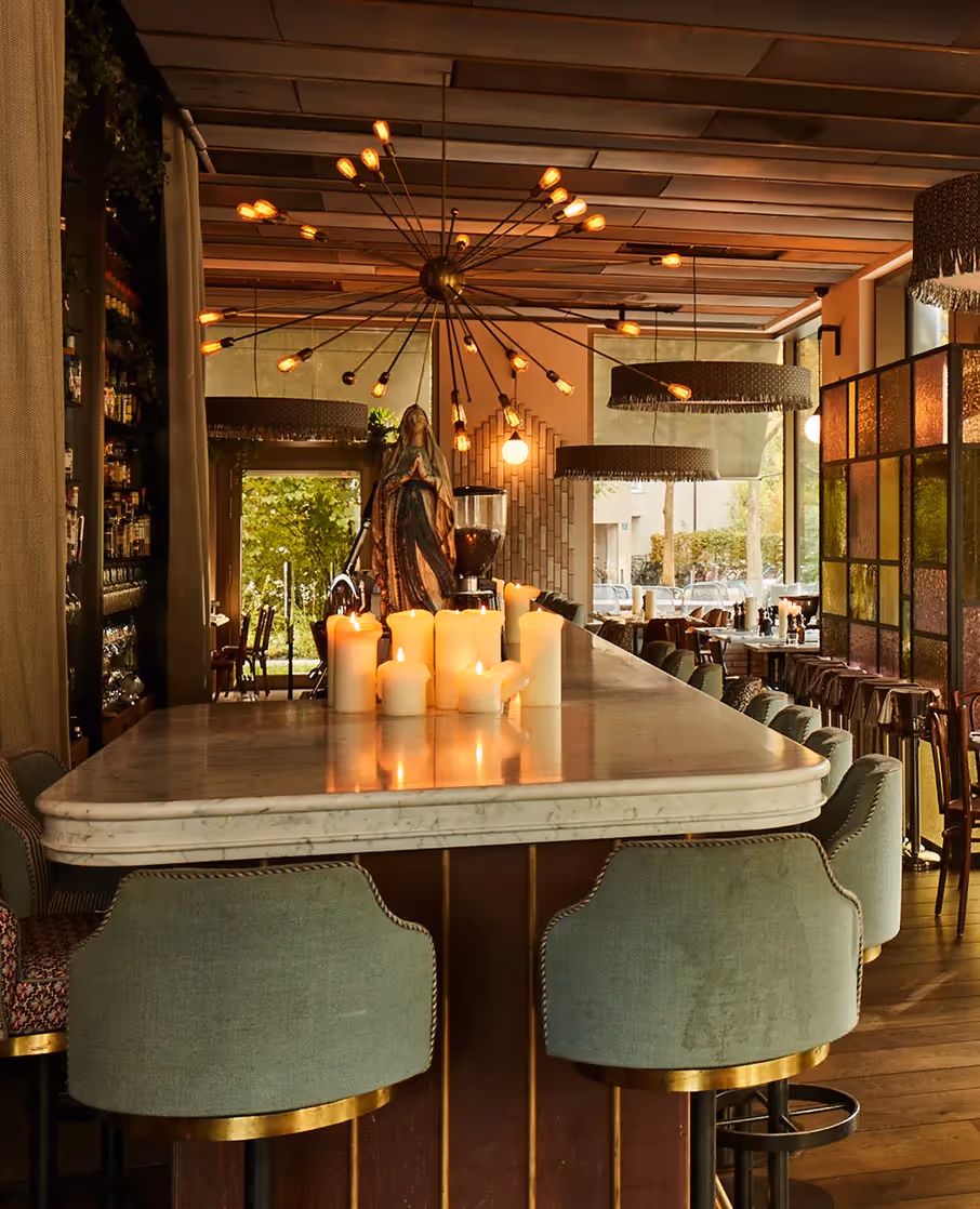 Barbereich im Restaurant mit Kerzenlicht, gepolsterten Stühlen und warmem Interior