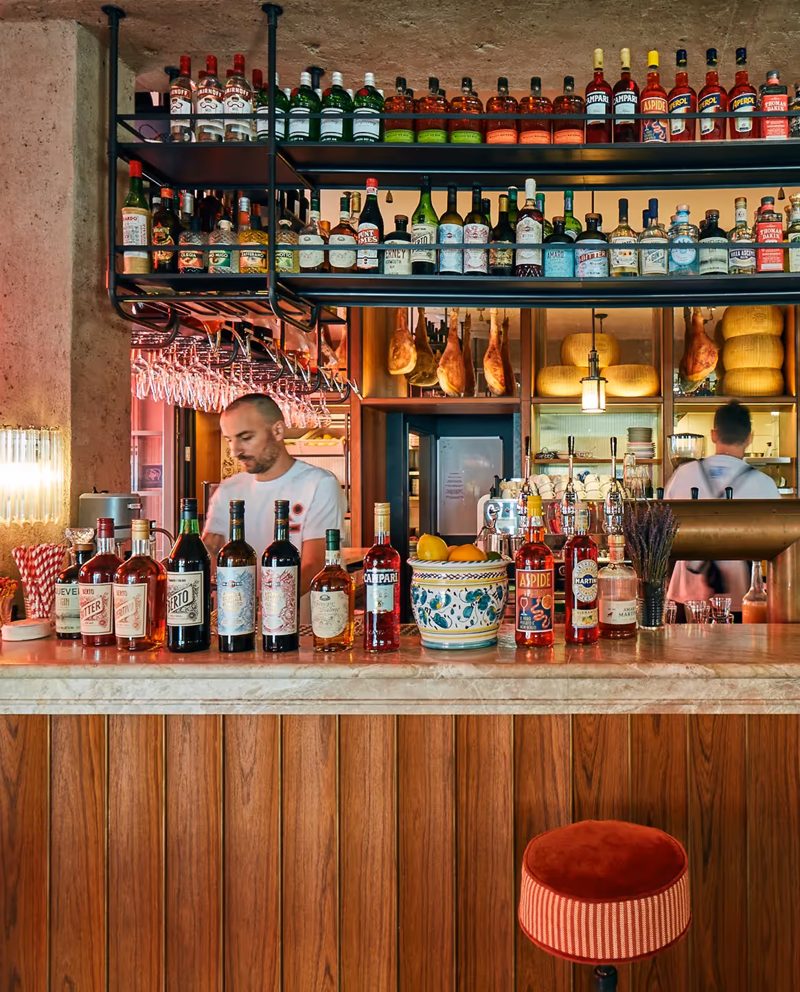 Barbereich mit bunten Fliesen, Spirituosen und warmem Licht