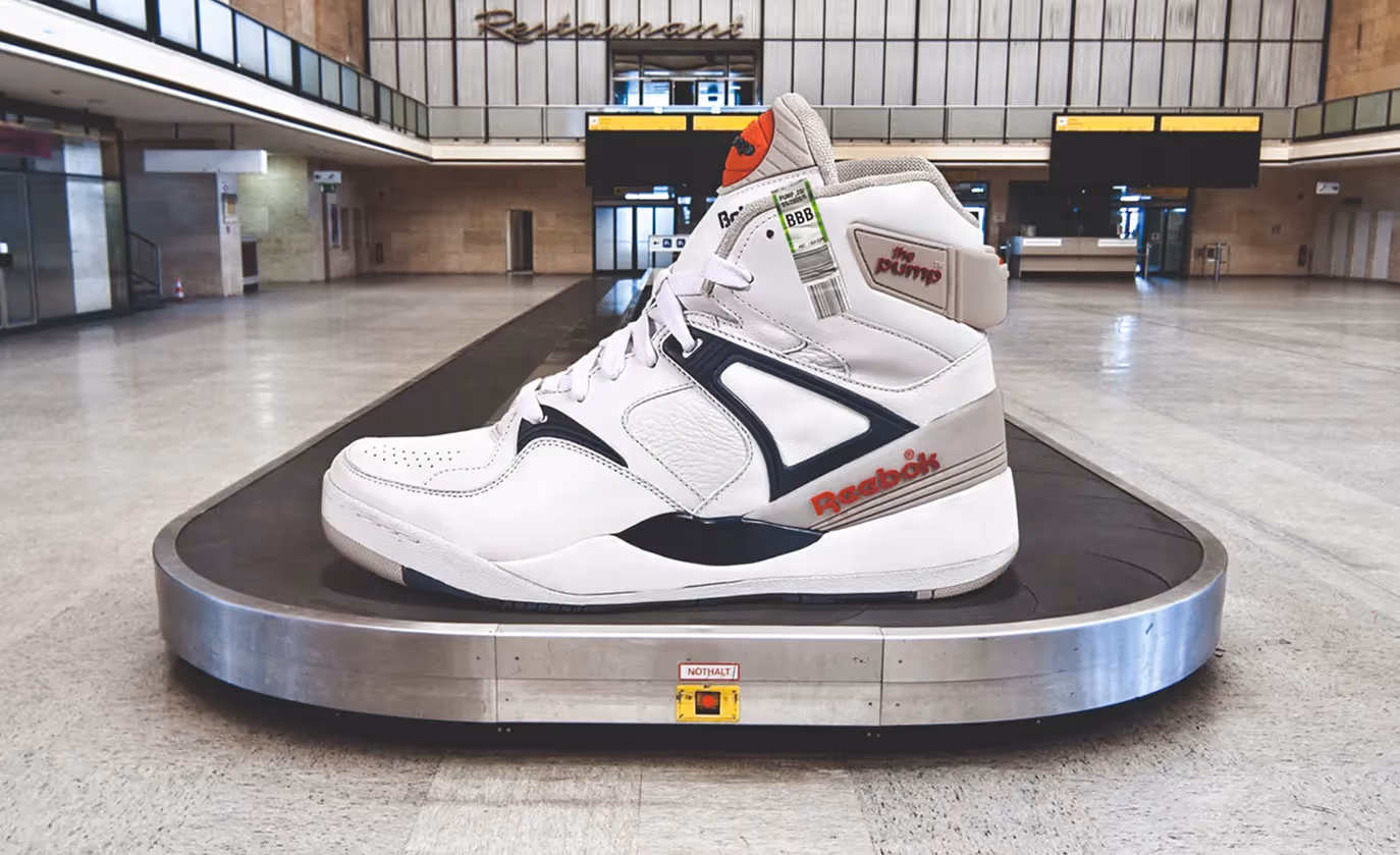 Ein einzelner Sportschuh steht auf einem Gepäckband in einer Halle