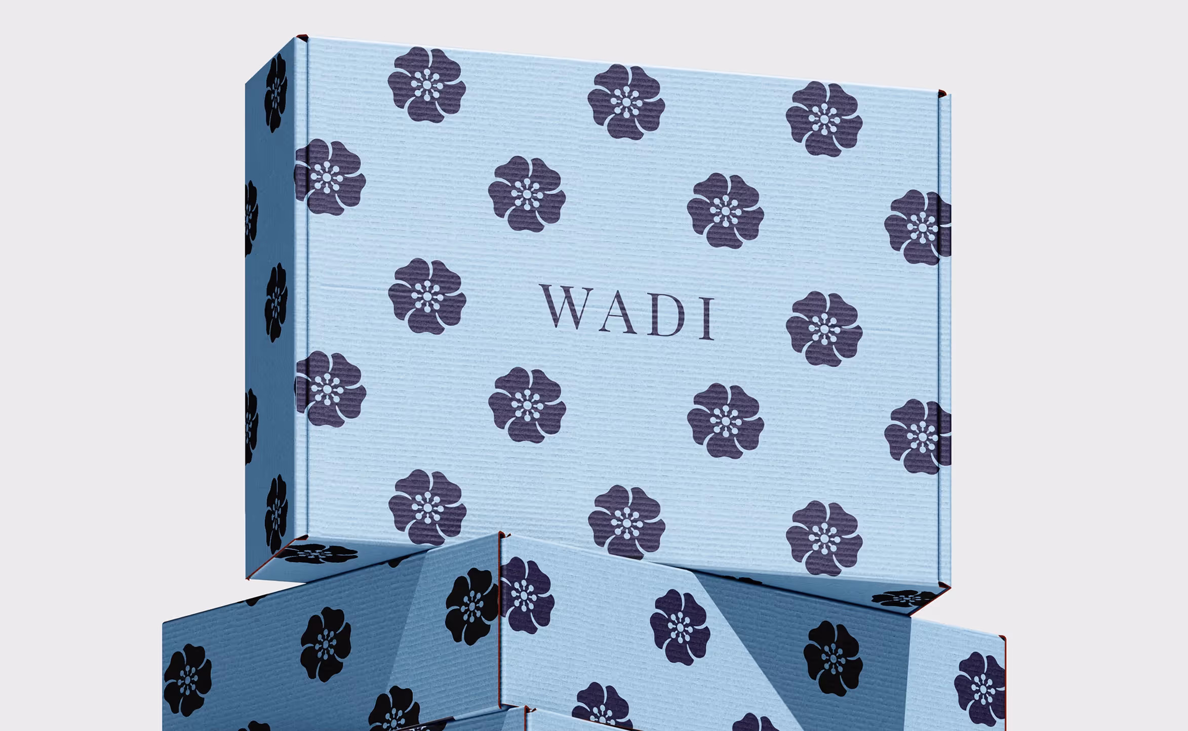 Verpackungsboxen mit blauem floralem Muster und WADI Branding