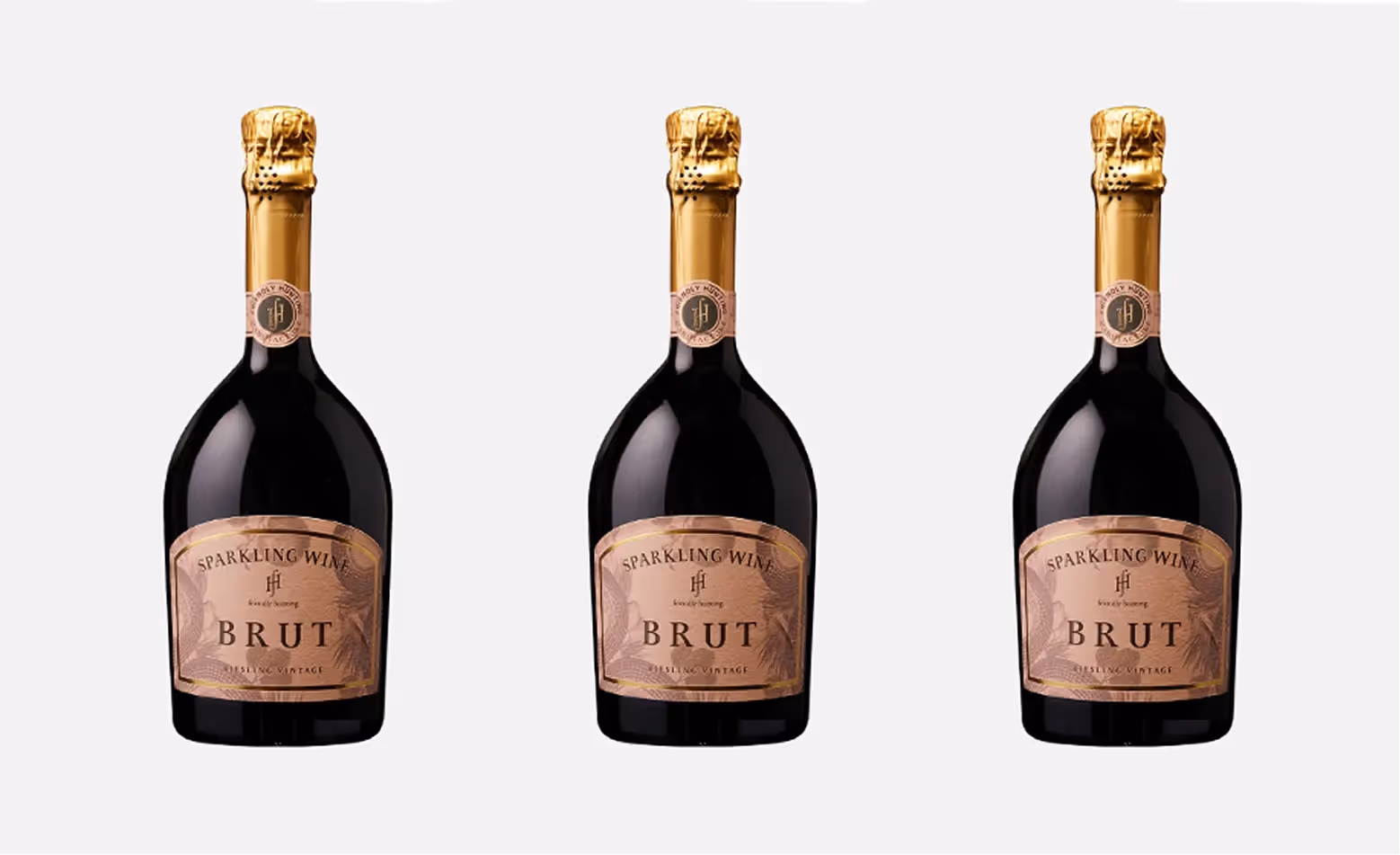 Drei Schaumwein Flaschen von Friendly Hunting stehen nebeneinander vor neutralem Hintergrund