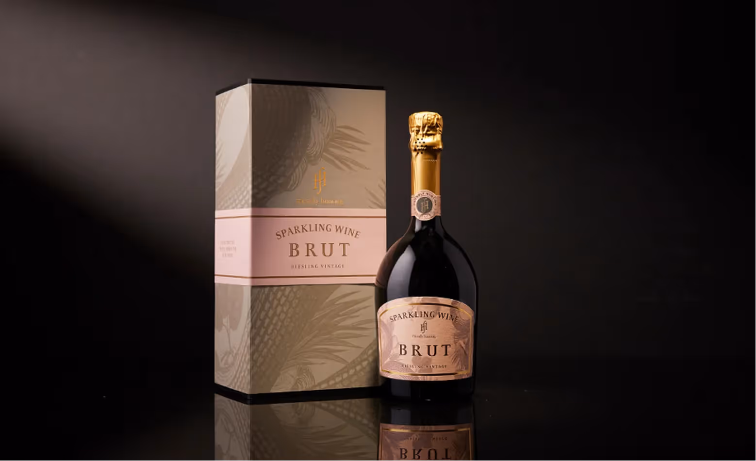 Flasche Schaumwein neben geschlossener Verpackungsbox auf dunklem Hintergrund