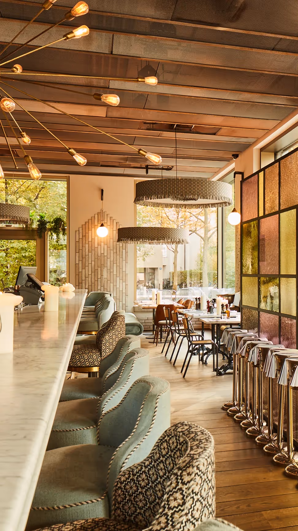 Marta Restaurant-Innenraum mit warmem Licht, Holzelementen und gedeckten Tischen