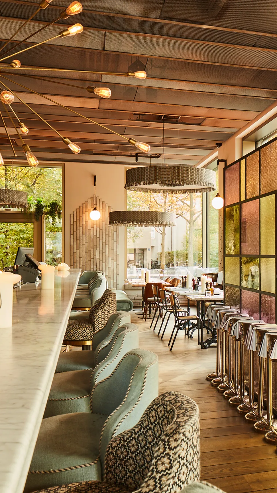 Marta Restaurant-Innenraum mit warmem Licht, Holzelementen und gedeckten Tischen