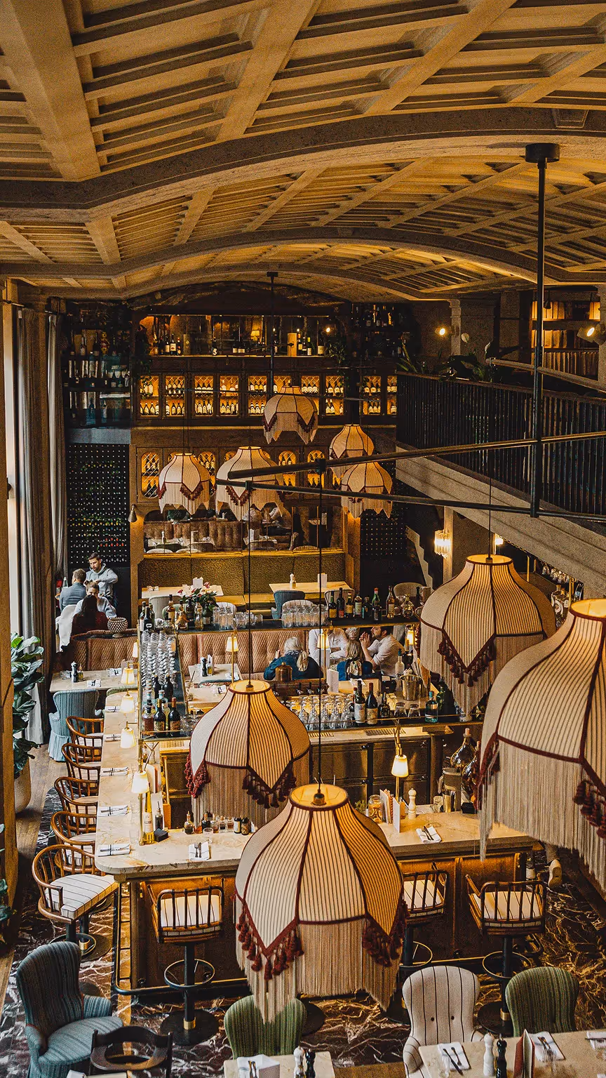 Restaurant-Innenraum mit Tischen, Lampen und dekorativer Beleuchtung
