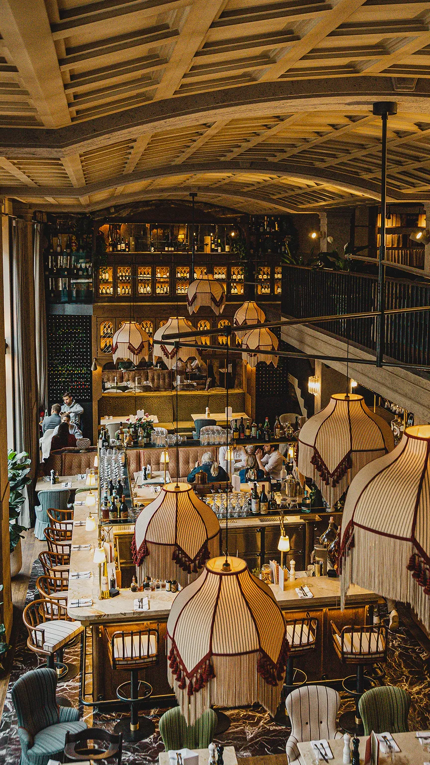 Restaurant-Innenraum mit Tischen, Lampen und dekorativer Beleuchtung