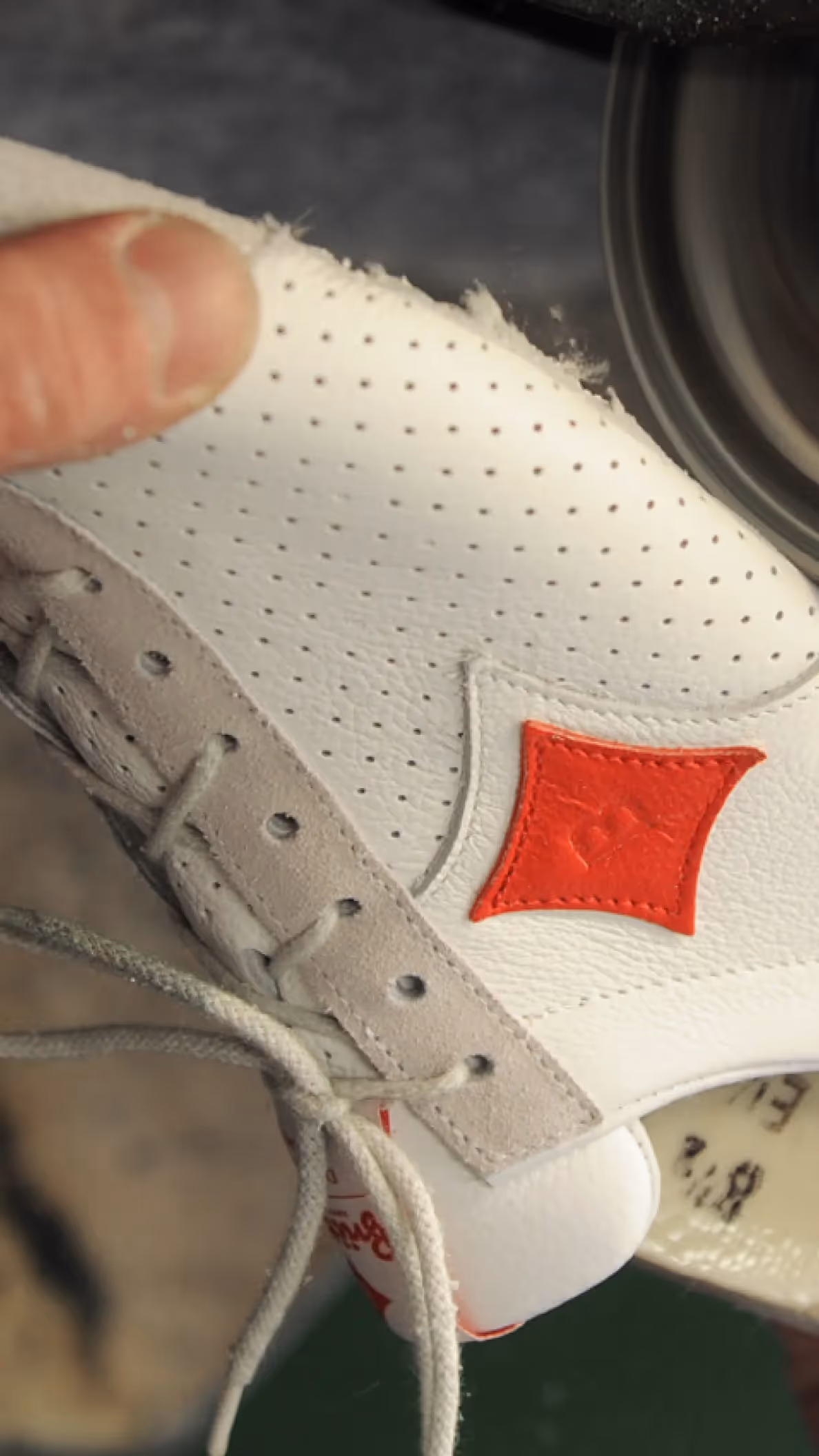 Handarbeit an einem Sneaker, bei der die Sohle manuell bearbeitet wird