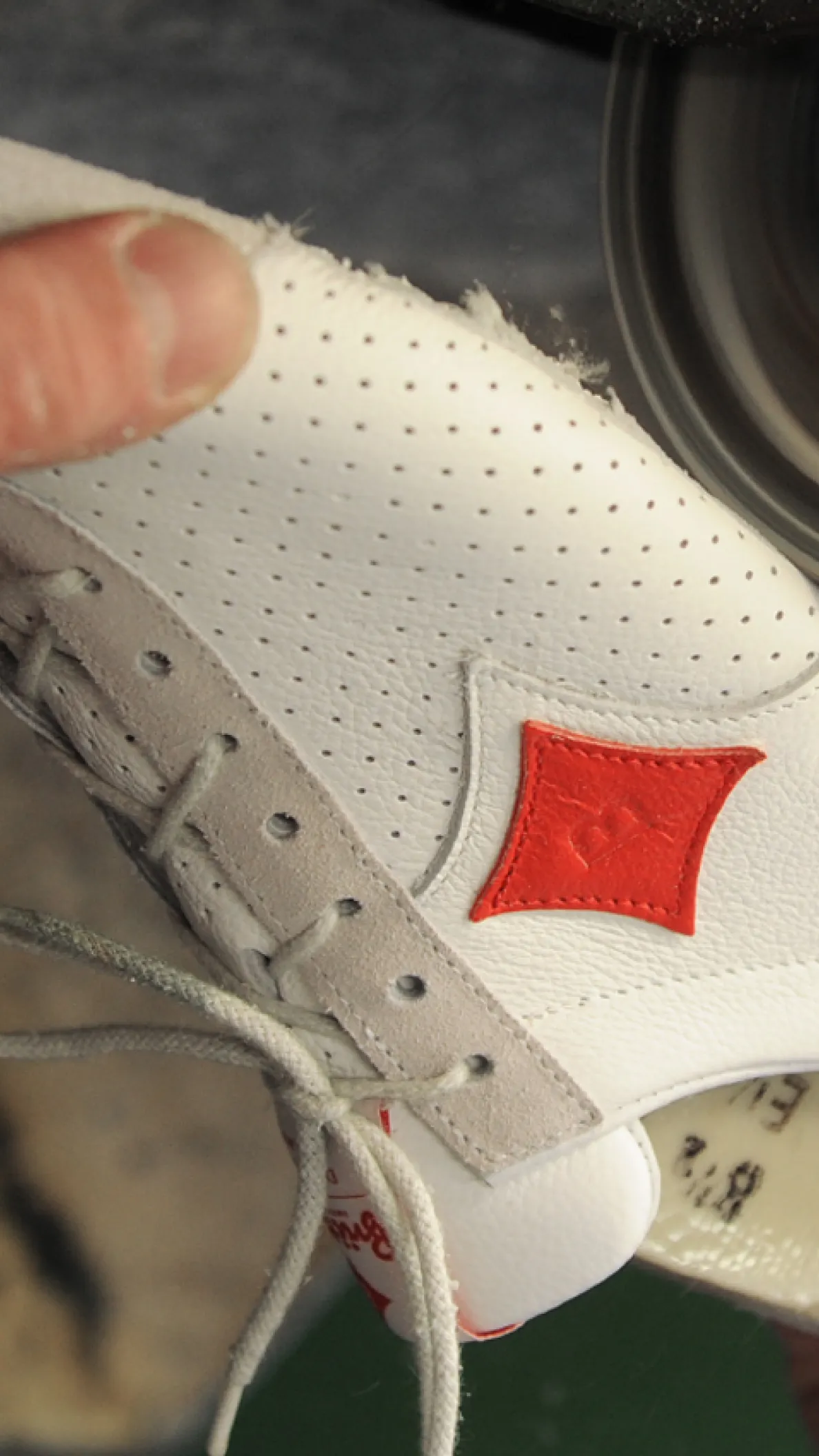 Handarbeit an einem Sneaker, bei der die Sohle manuell bearbeitet wird