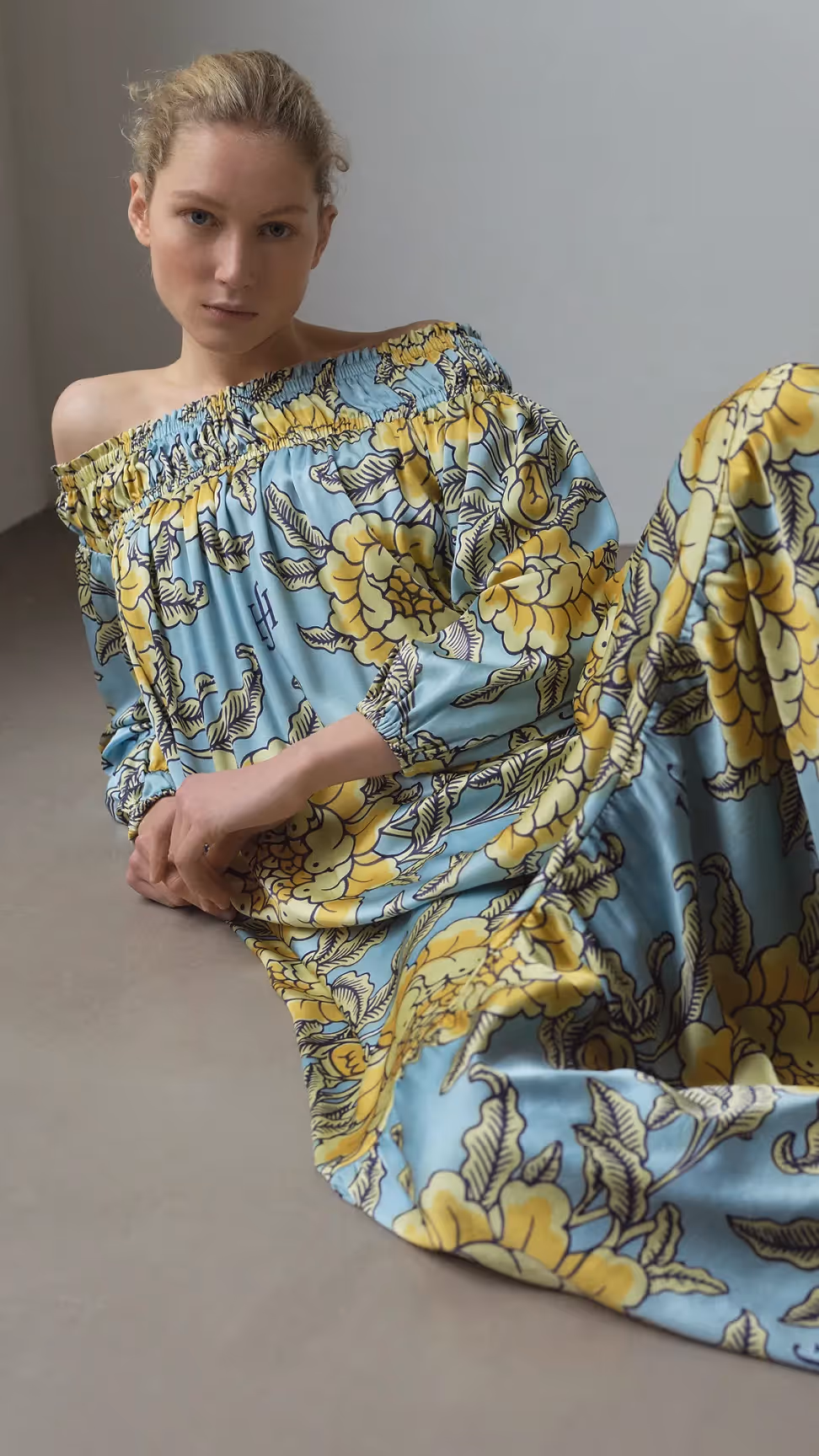 Frau liegt in einem farbenfrohen Kleid mit floralen Mustern aus der Friendly Hunting Kollektion