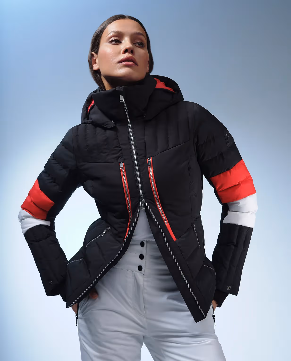Frau in schwarzer Winterjacke mit roten Details und technischer Performance für die HEAD Kampagne