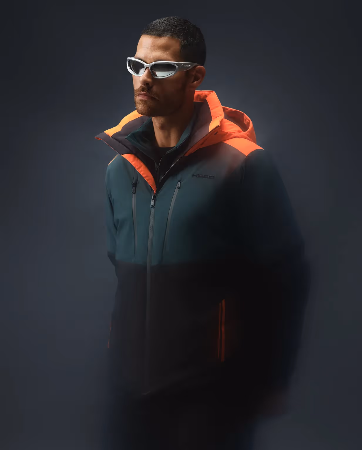 Detailaufnahme einer technischen Outdoorjacke mit Kapuze und Sportbrille aus der HEAD Kollektion
