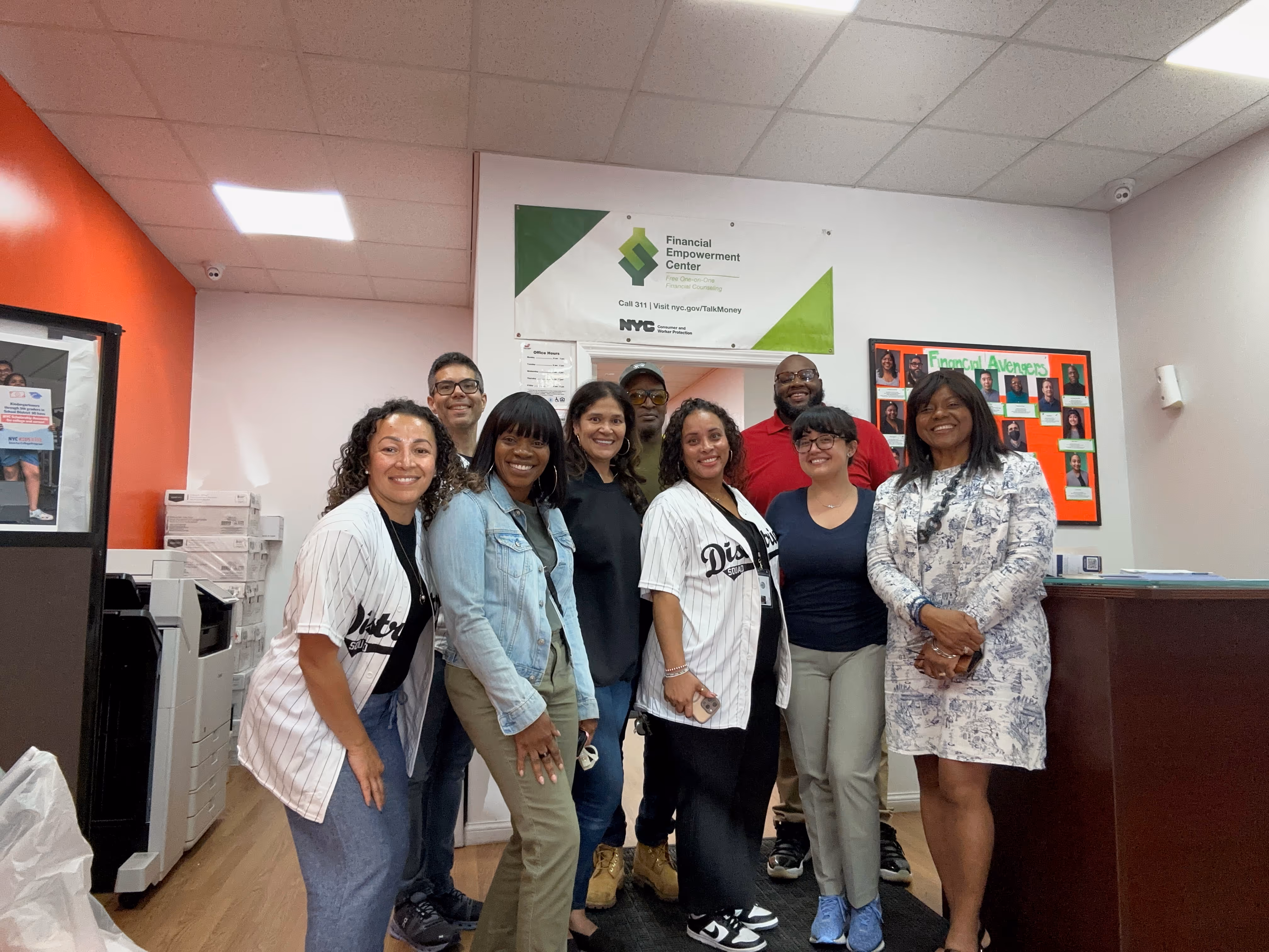 ACE staff and community members pose for a group photo in a school hallway