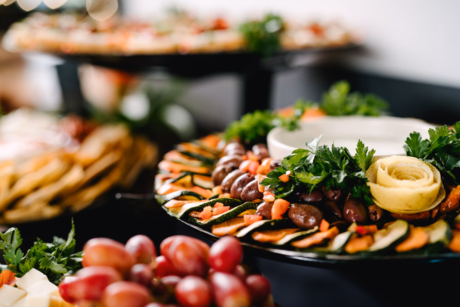 Squatters catering platter of grilled vegetables, olives and cheeses with crackers and grapes