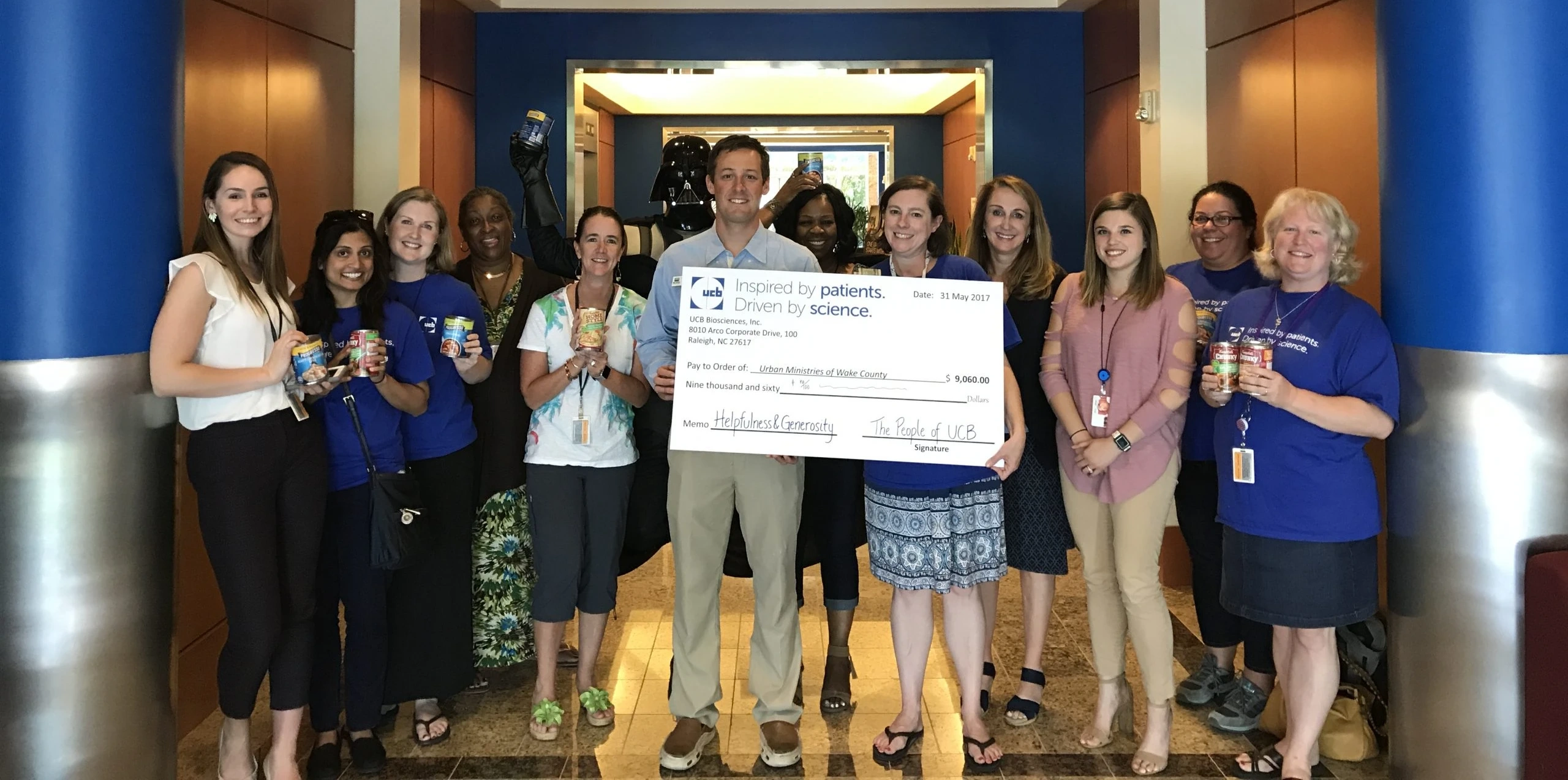 UCB Biosciences staff handing off a $9,060 check to the Urban Ministries staff