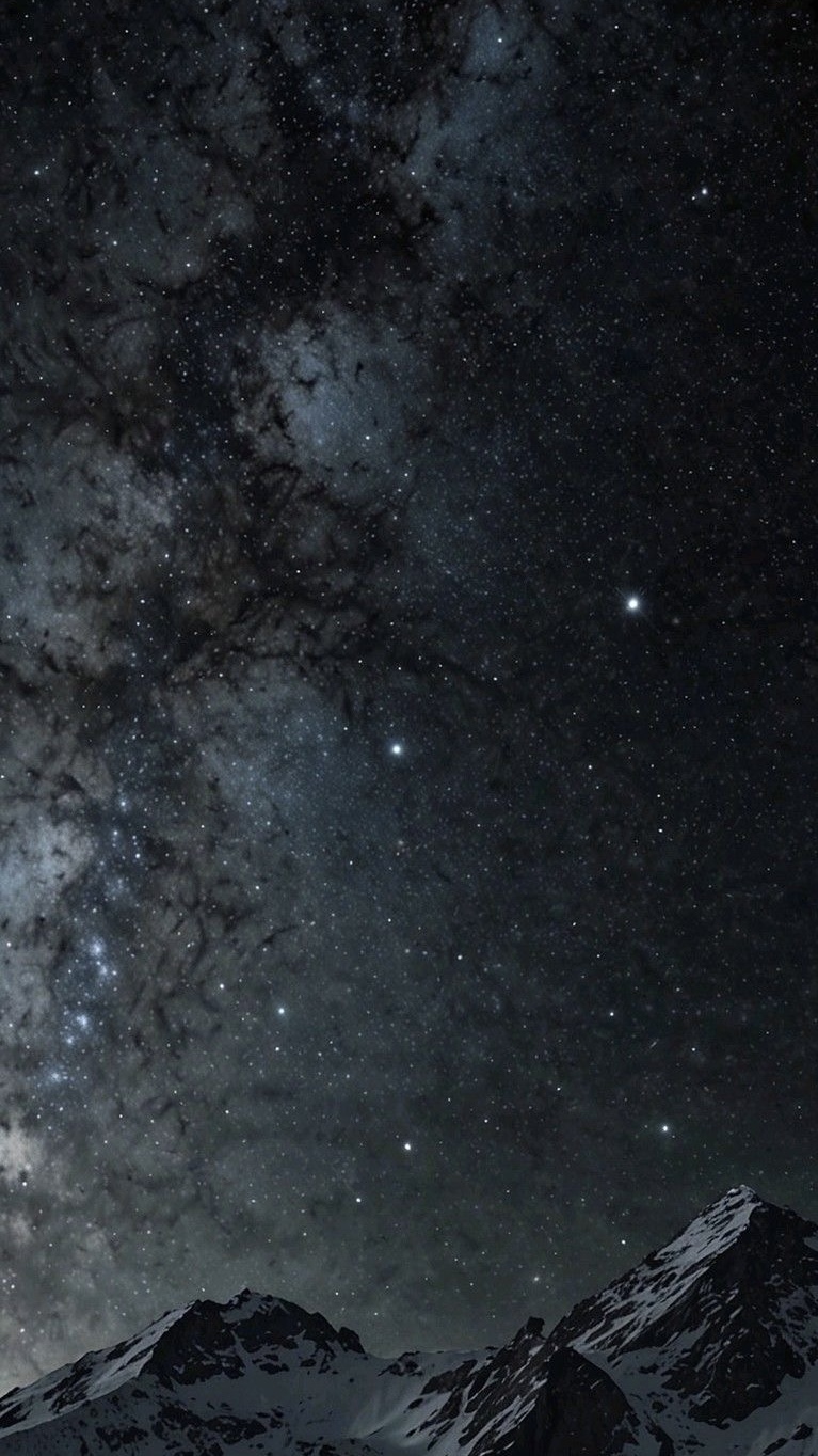 Snow-covered mountain peaks under a clear night sky filled with stars and the Milky Way.