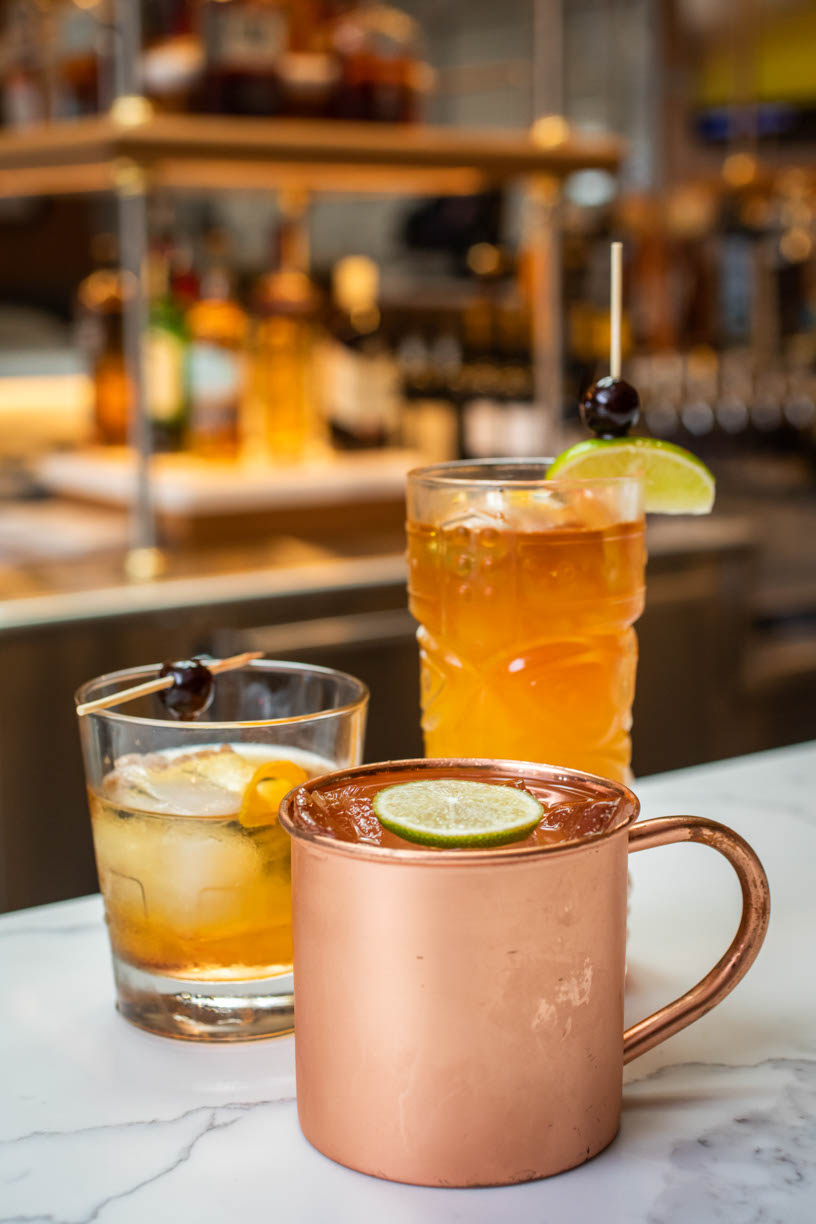 Image of 3 cocktail drinks. 3 cups full of ice and alcohol with beautiful garnishes