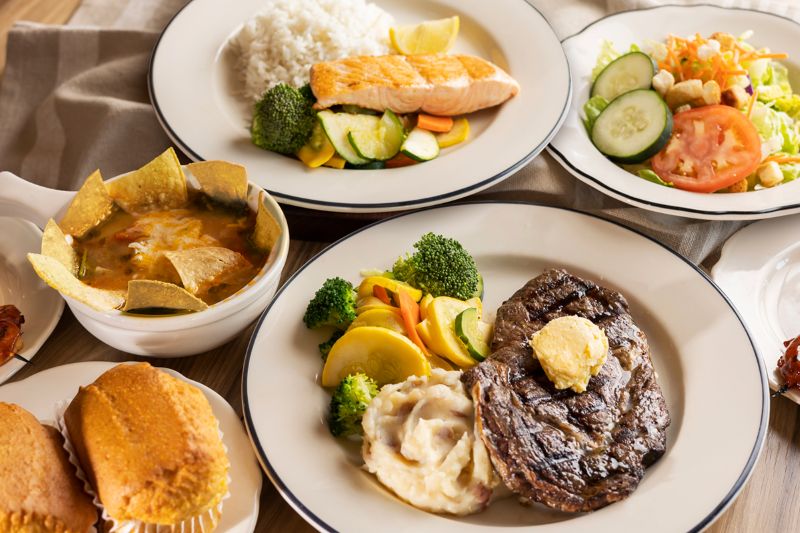 Two short wine glasses being filled with  wine. One is white wine the other is red.