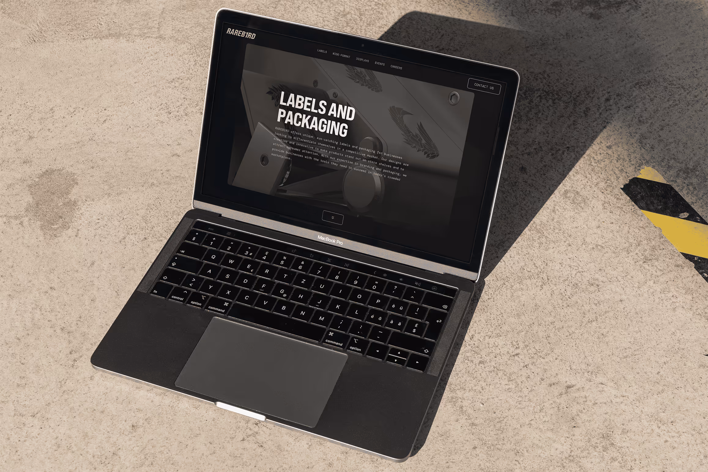 Rareb1rd website labels & packaging page on laptop with concrete floor