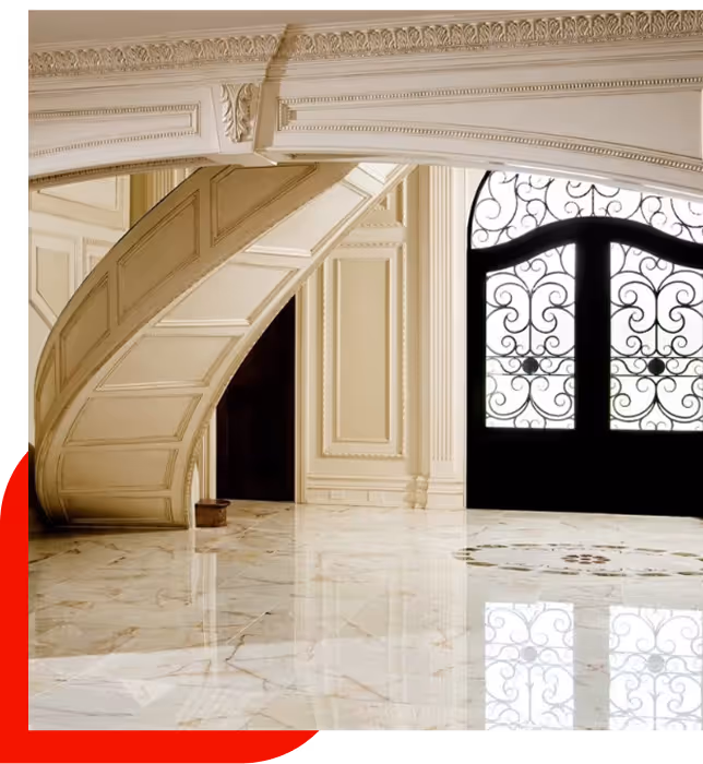 Elegant interior with a white curved staircase, ornate wall paneling, polished marble floor, and large decorative iron doors.