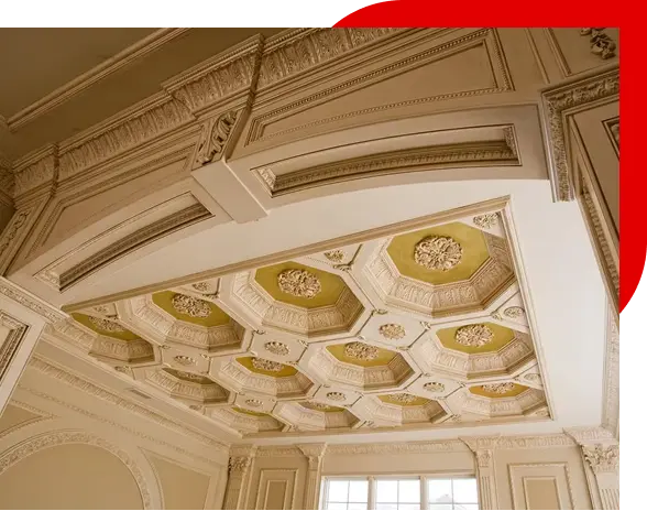 Ceiling with ornate plasterwork featuring octagonal recessed panels and floral motifs in a classical interior.