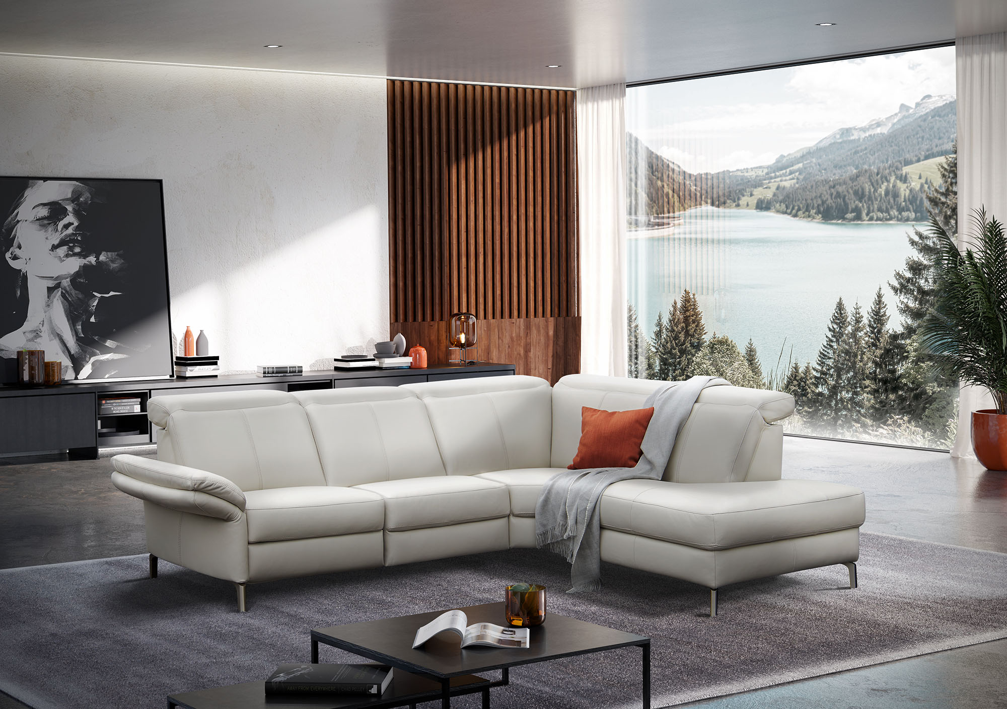 Graue Couch mit roten Kissen in einem hellen Wohnzimmer