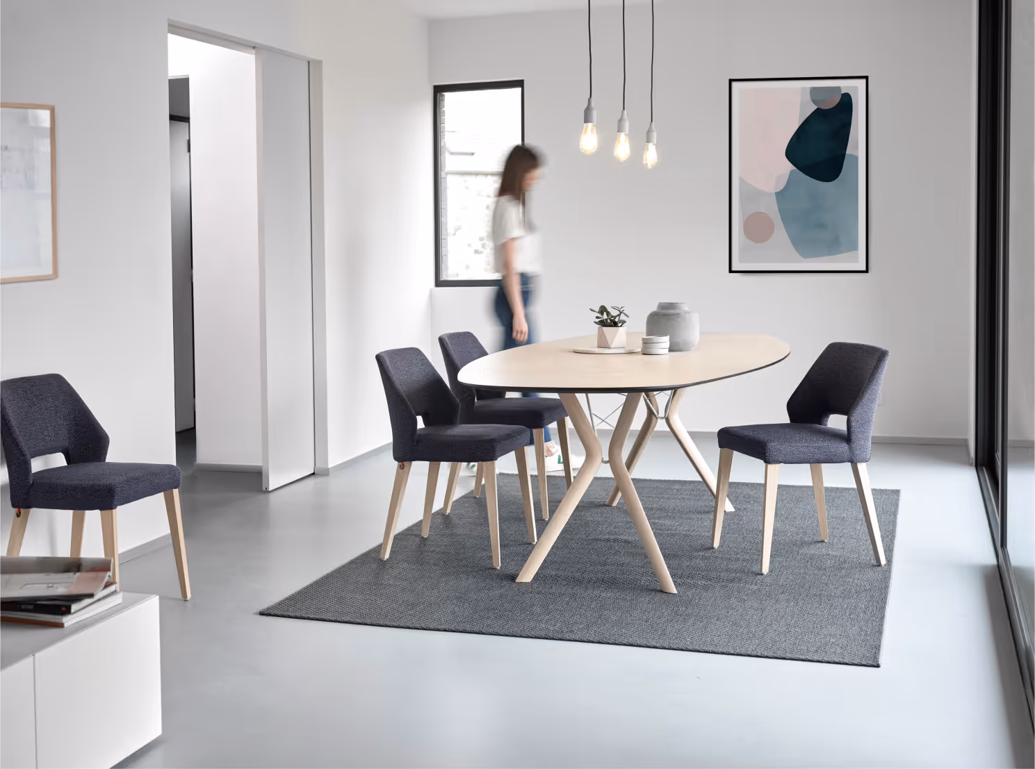 Esszimmer mit Holztisch und dunkelblauen Stühlen auf Teppich