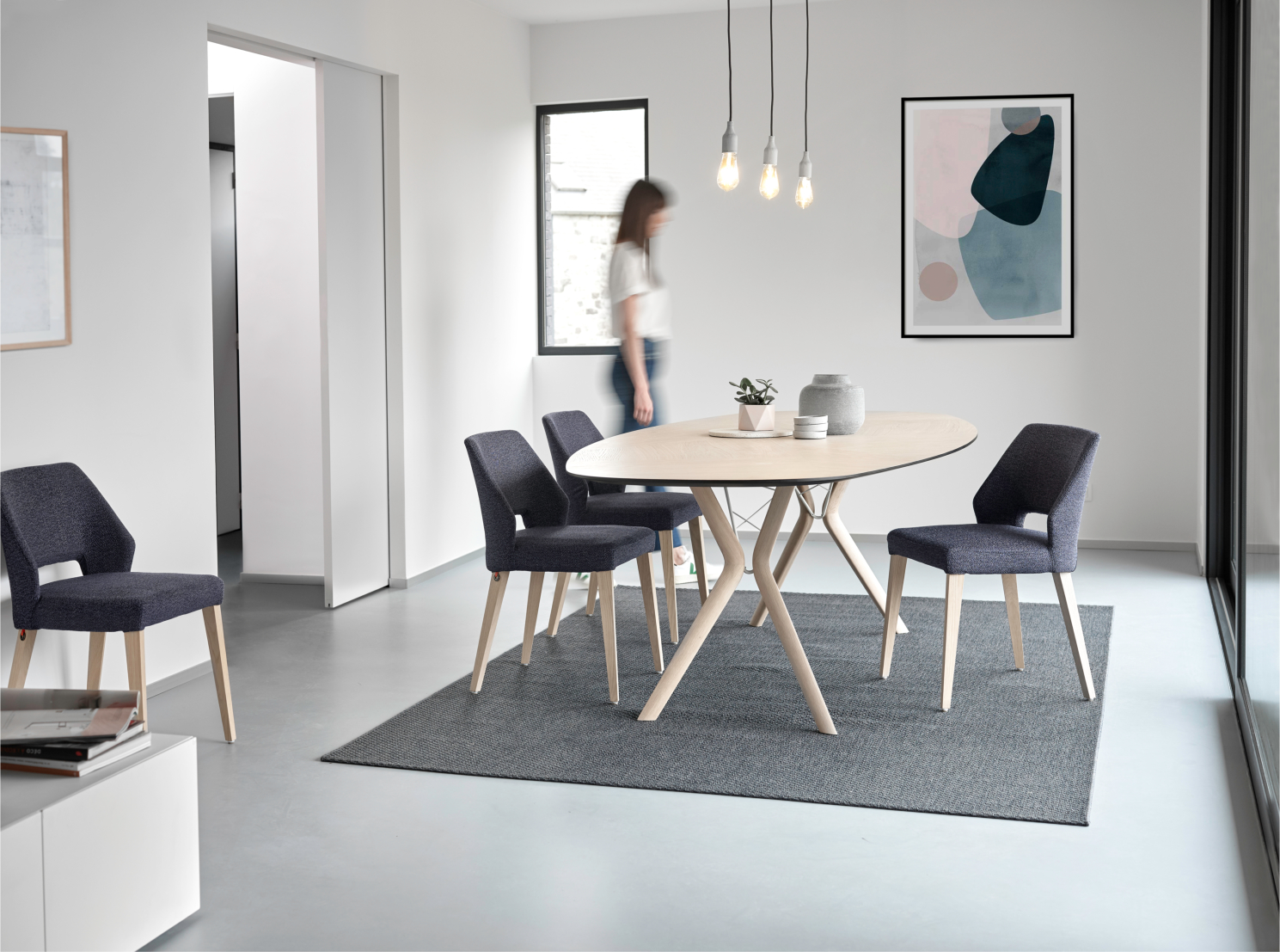 Esszimmer mit Holztisch und dunkelblauen Stühlen auf Teppich