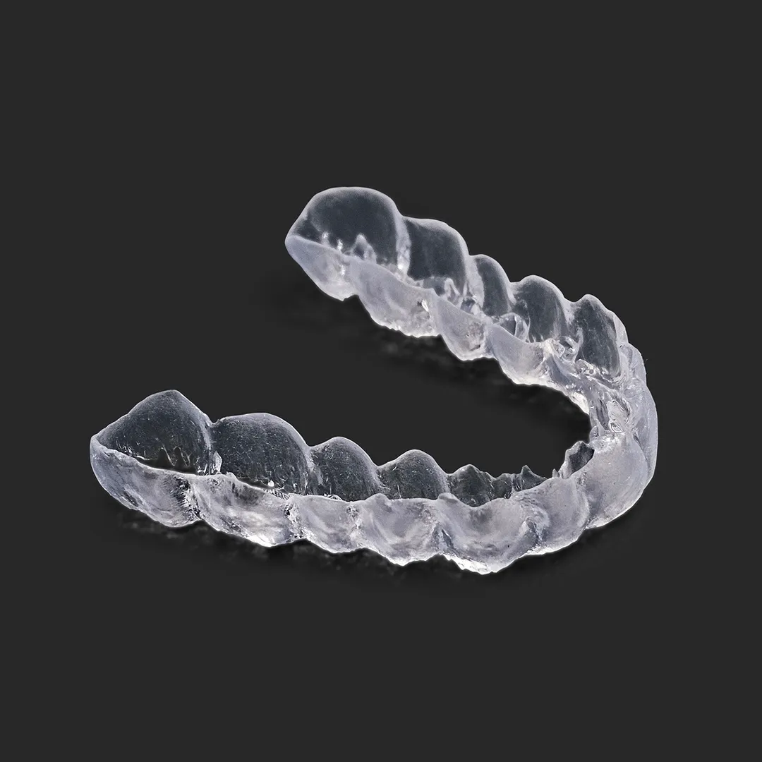 A clear plastic object on a black background.