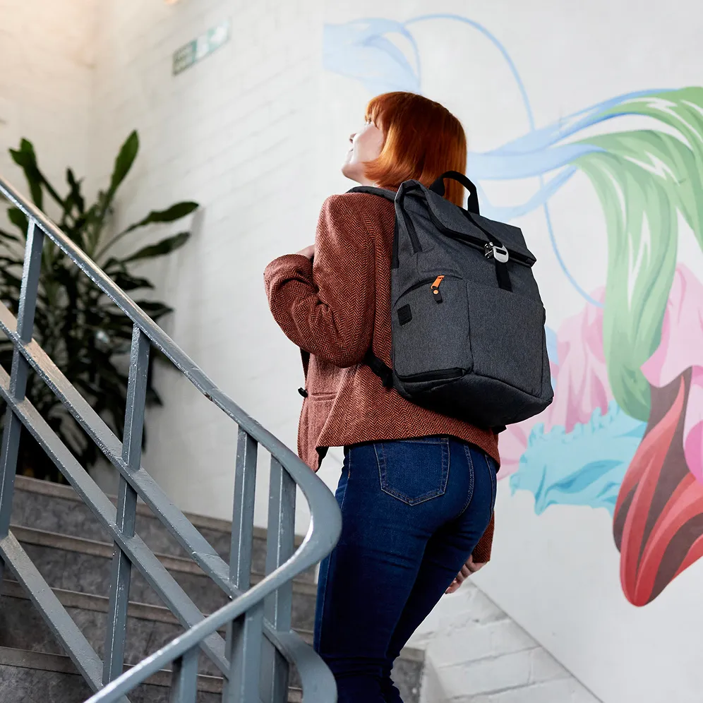 Une femme avec un sac à dos Hotbox Shuttle montant un escalier.