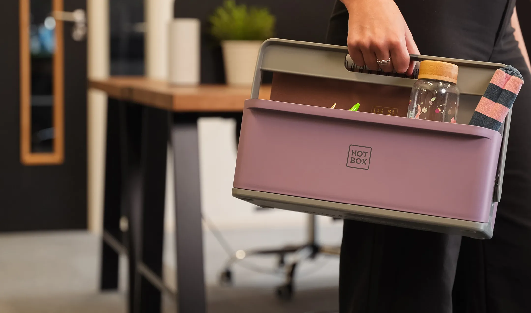 A person holding a pink Hotbox 4 mini with a bottle in it.