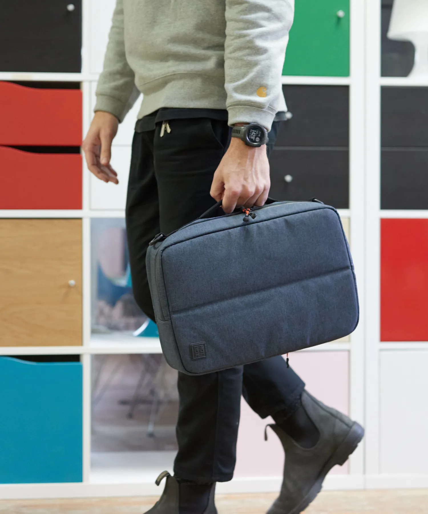 Un homme marchant avec une valise Hotbox à la main.