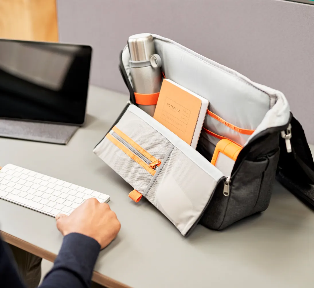 A person sitting at a desk with a laptop and a Hotbox carry case.