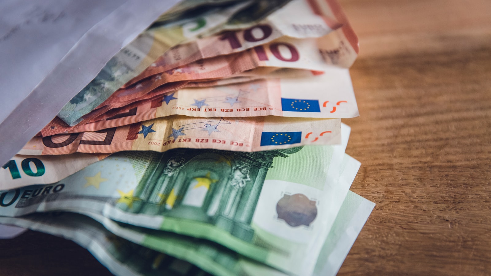 Billets en euros étalés sur une surface en bois
