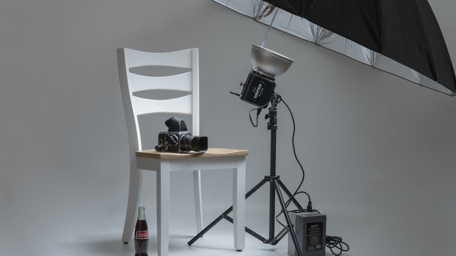 Caméra vidéo et parapluie de studio installés pour un tournage produit