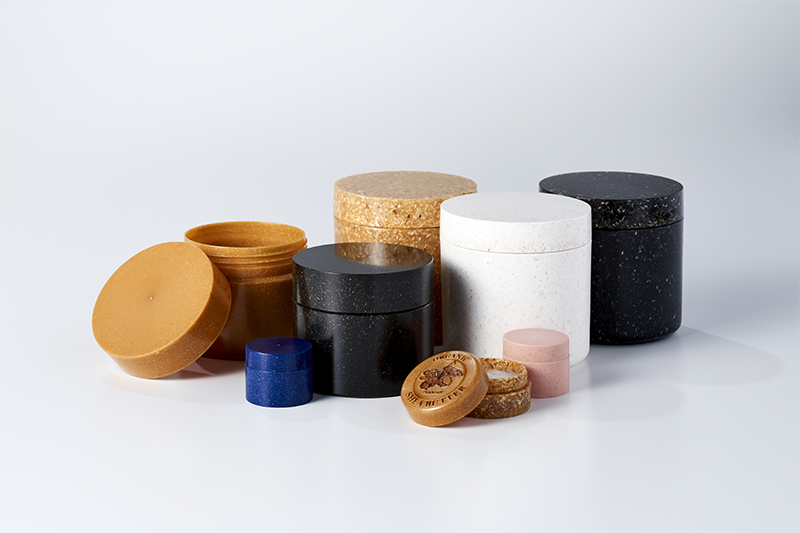 Collection of sustainable cosmetic jars and eco-friendly containers in assorted colors, showcasing biodegradable packaging for beauty and skincare products.
