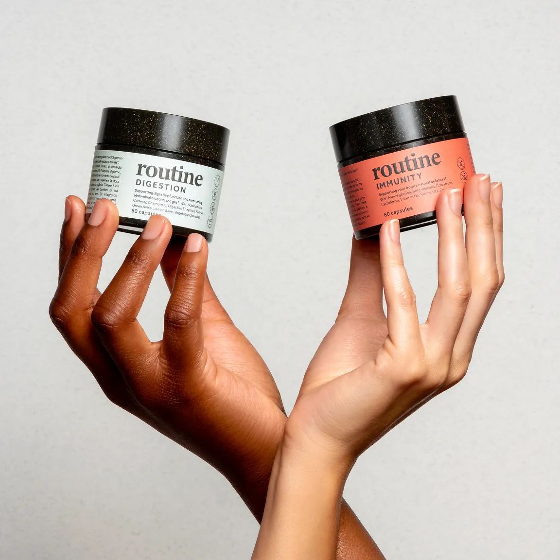 Two hands holding Routine Vitamins' product