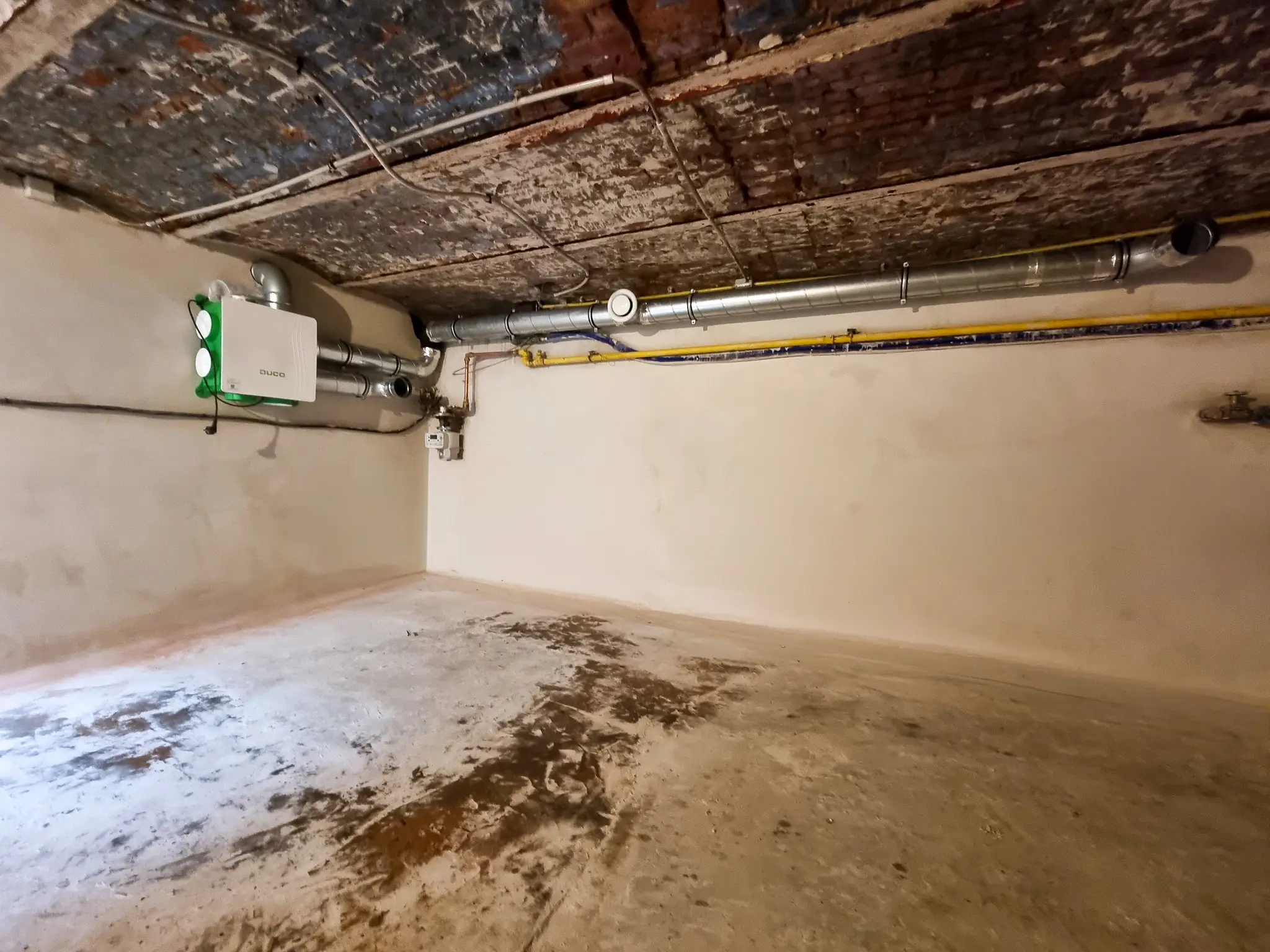 Behandelde kelder met afgewerkte wanden en een geplaatste ventilatie-unit