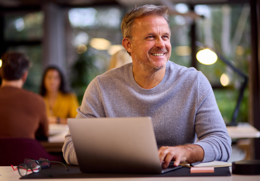 Satisfied business owner or project manager using ONSO on a laptop in a modern office, highlighting efficiency and control over financial management and procurement.