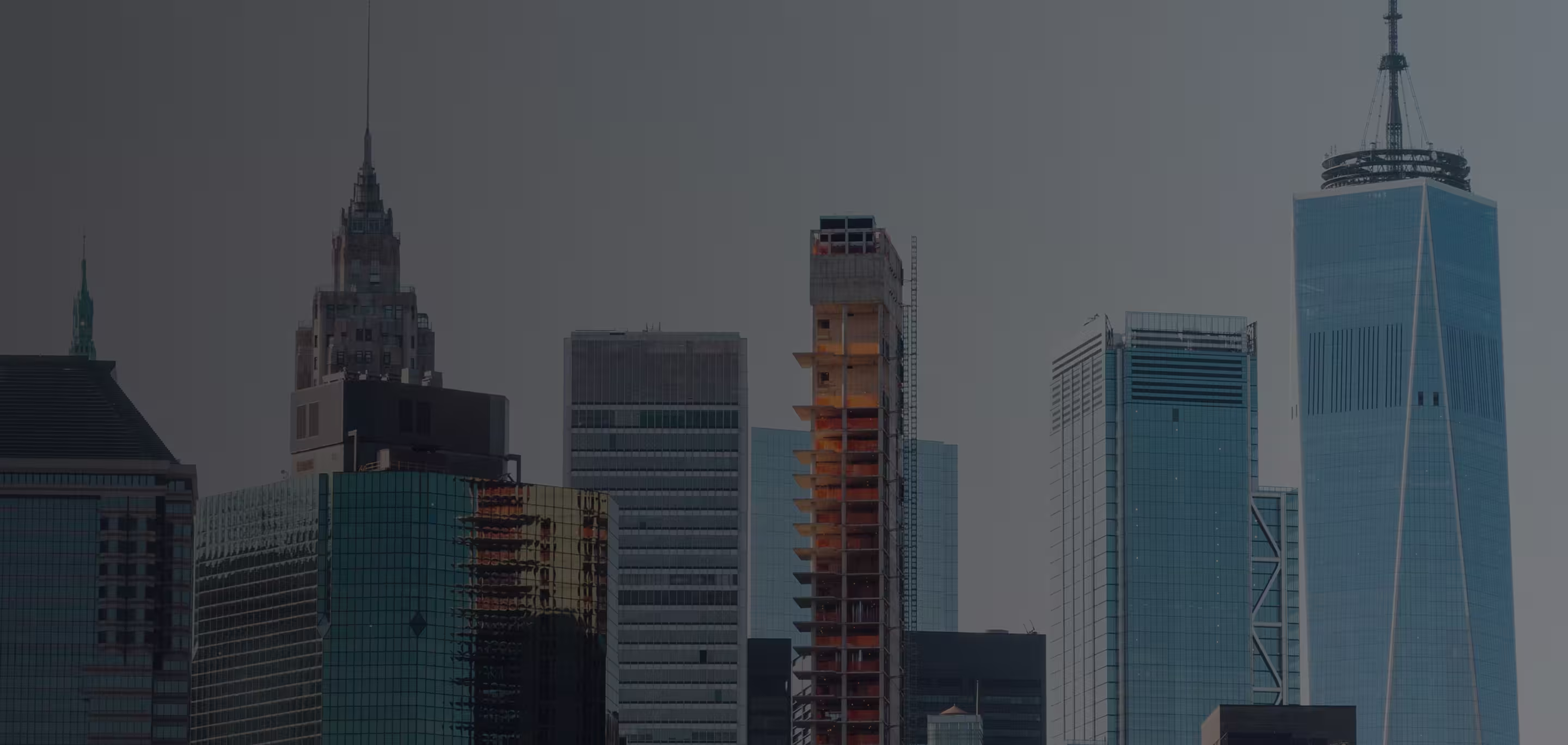 City skyline with modern high-rise buildings including a prominent glass tower.