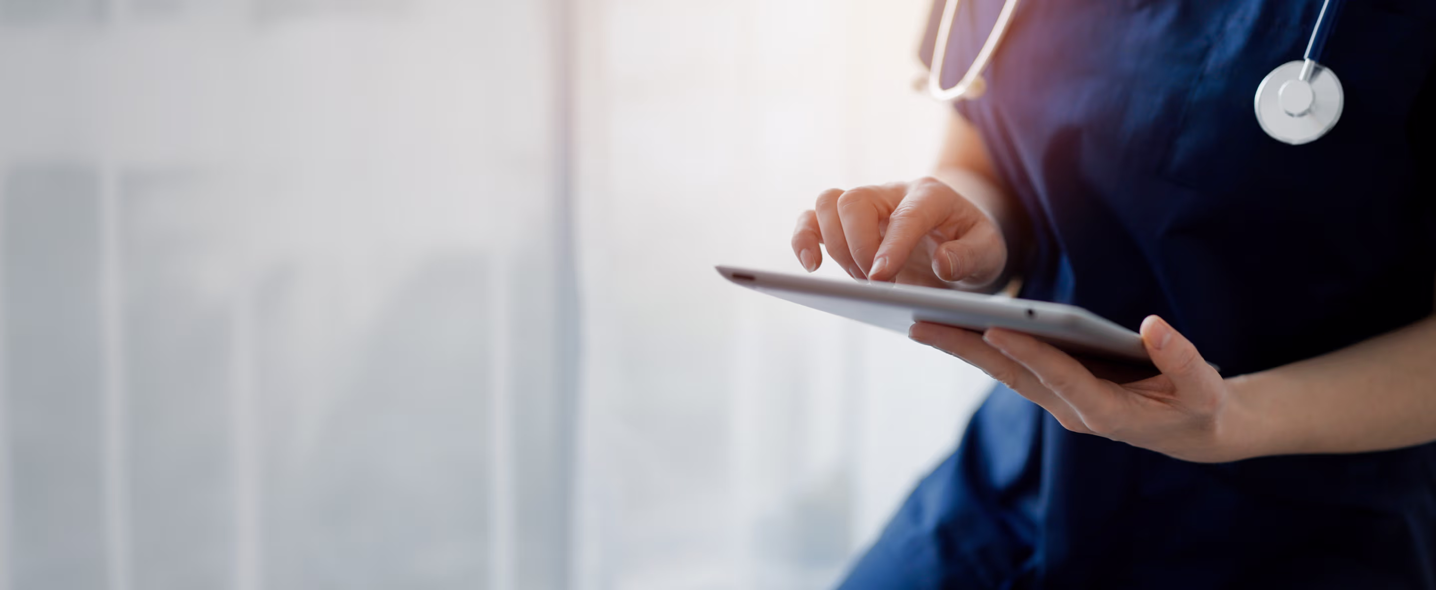 Provet medical professional using tablet with stethoscope in clinical setting