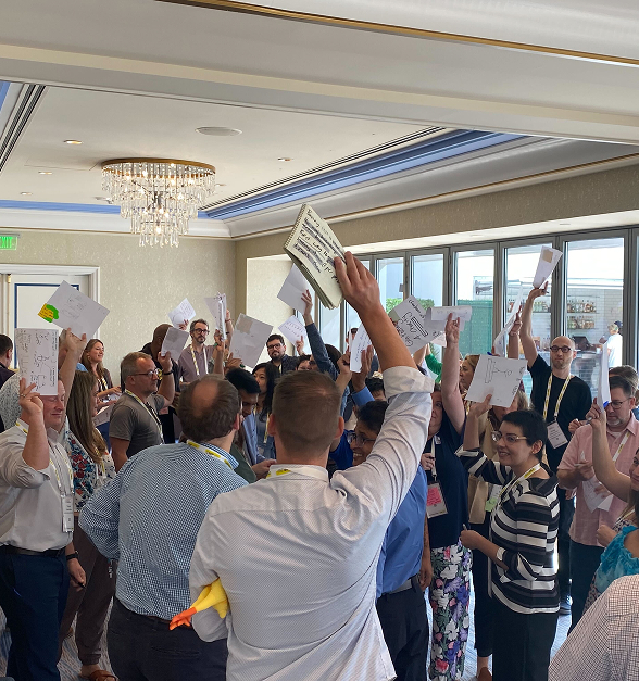 Picture of Aaron facilitating a large conference workshop.