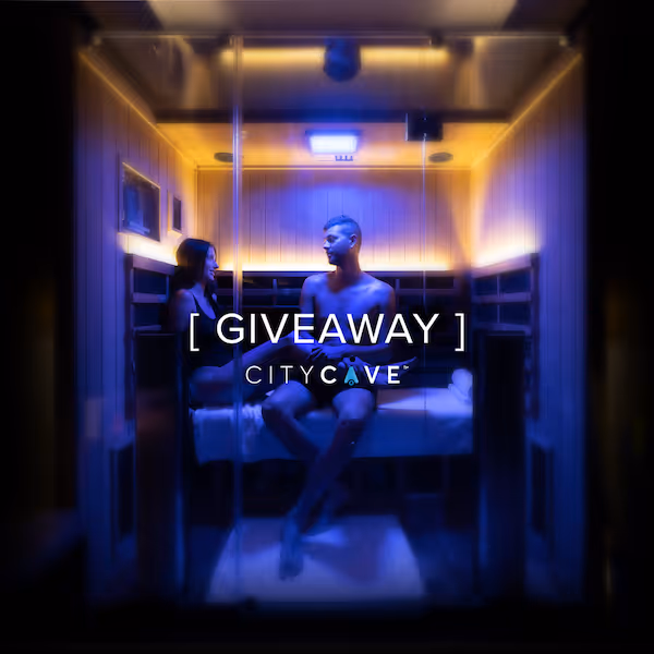 A man and woman sitting inside a softly lit sauna with the text '[ GIVEAWAY ] CITYCAVE' overlaid.