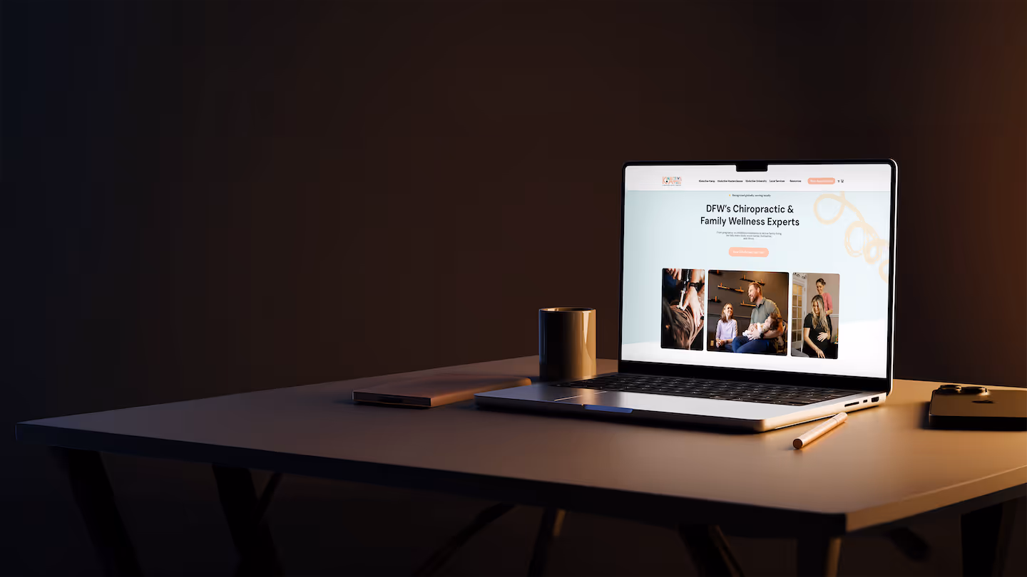 Laptop on a desk displaying a chiropractic and family wellness website, surrounded by a coffee mug, pen, and phone.