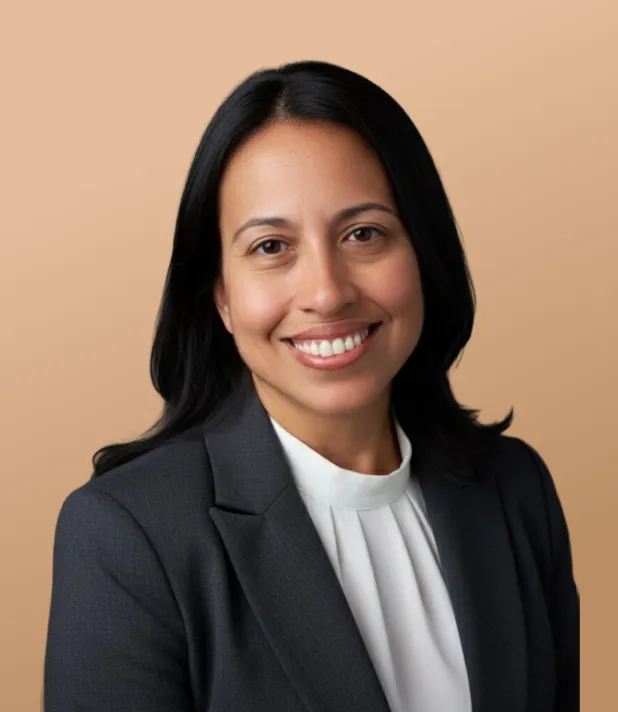 Woman in a suit smiling in a studio portrait.