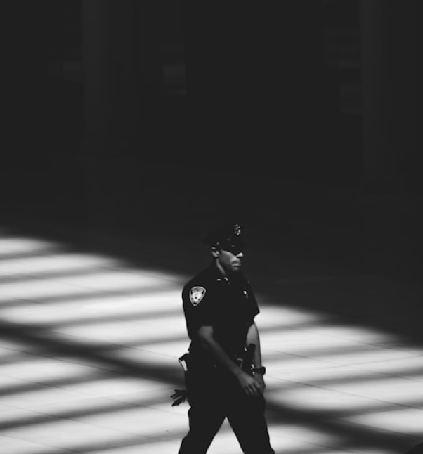 Police officer walking through a dimly lit area.
