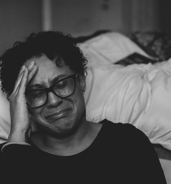 Person crying with a hand on their head.