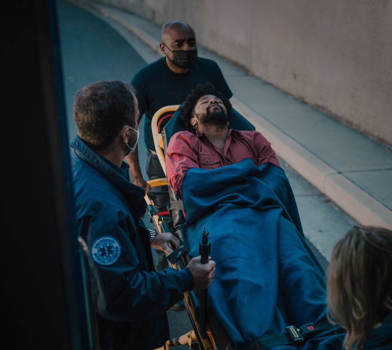 Woman holding her neck while looking at her phone near a car accident.