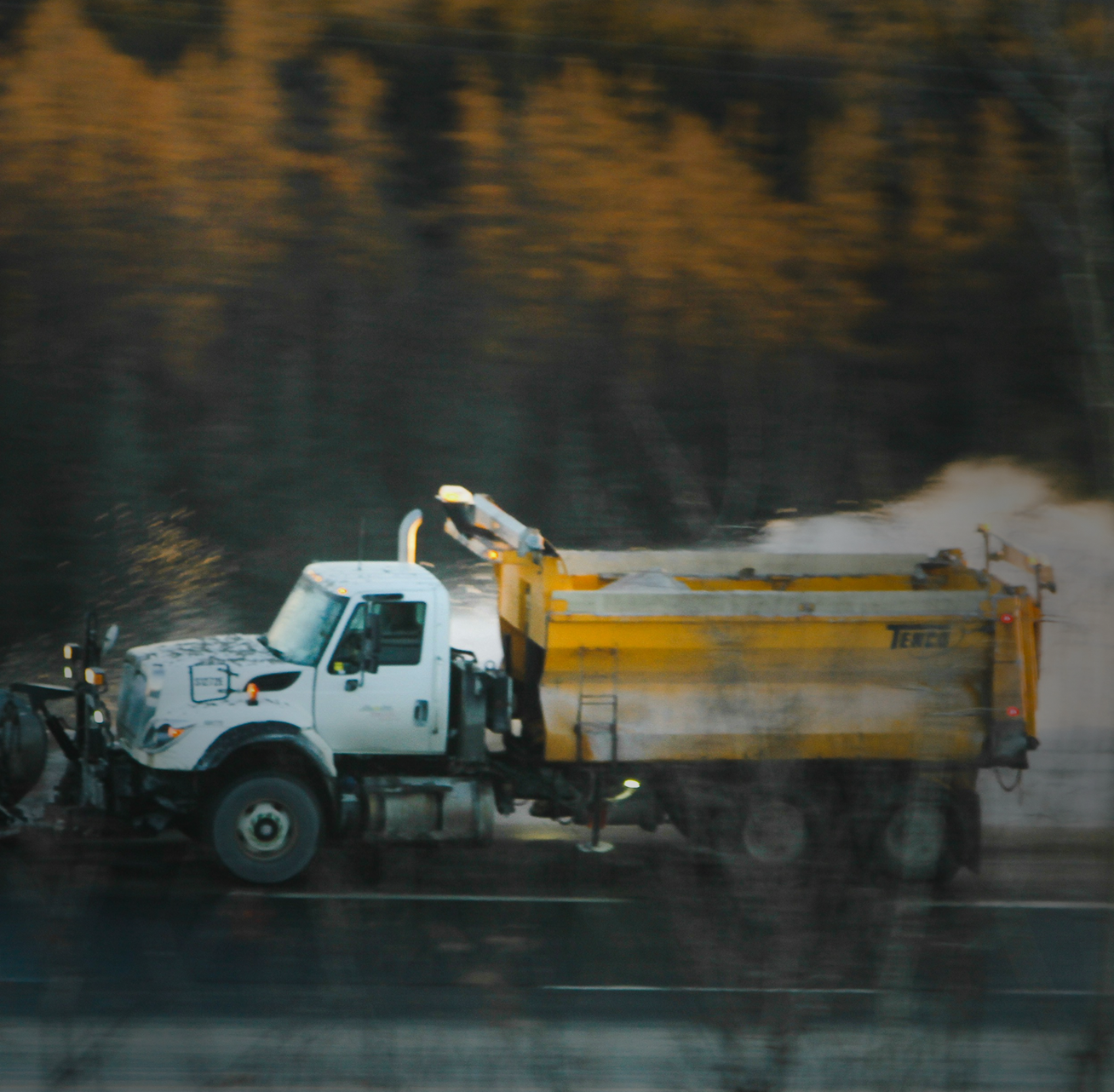 Woman holding her neck while looking at her phone near a car accident.
