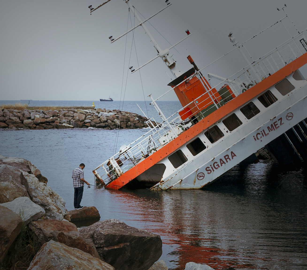 Woman holding her neck while looking at her phone near a car accident.